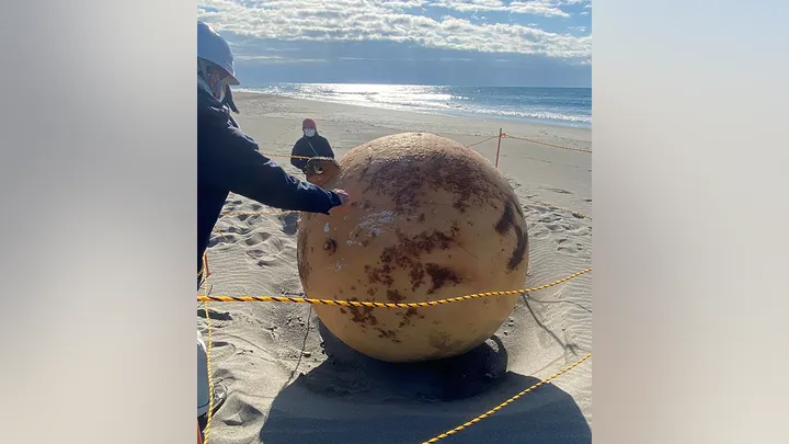 On Tuesday, Japanese officials launched an investigation into a massive, inexplicable metal ball discovered on a beach by a lady. As part of the inquiry, the beach in Hamamatsu was closed to the public.