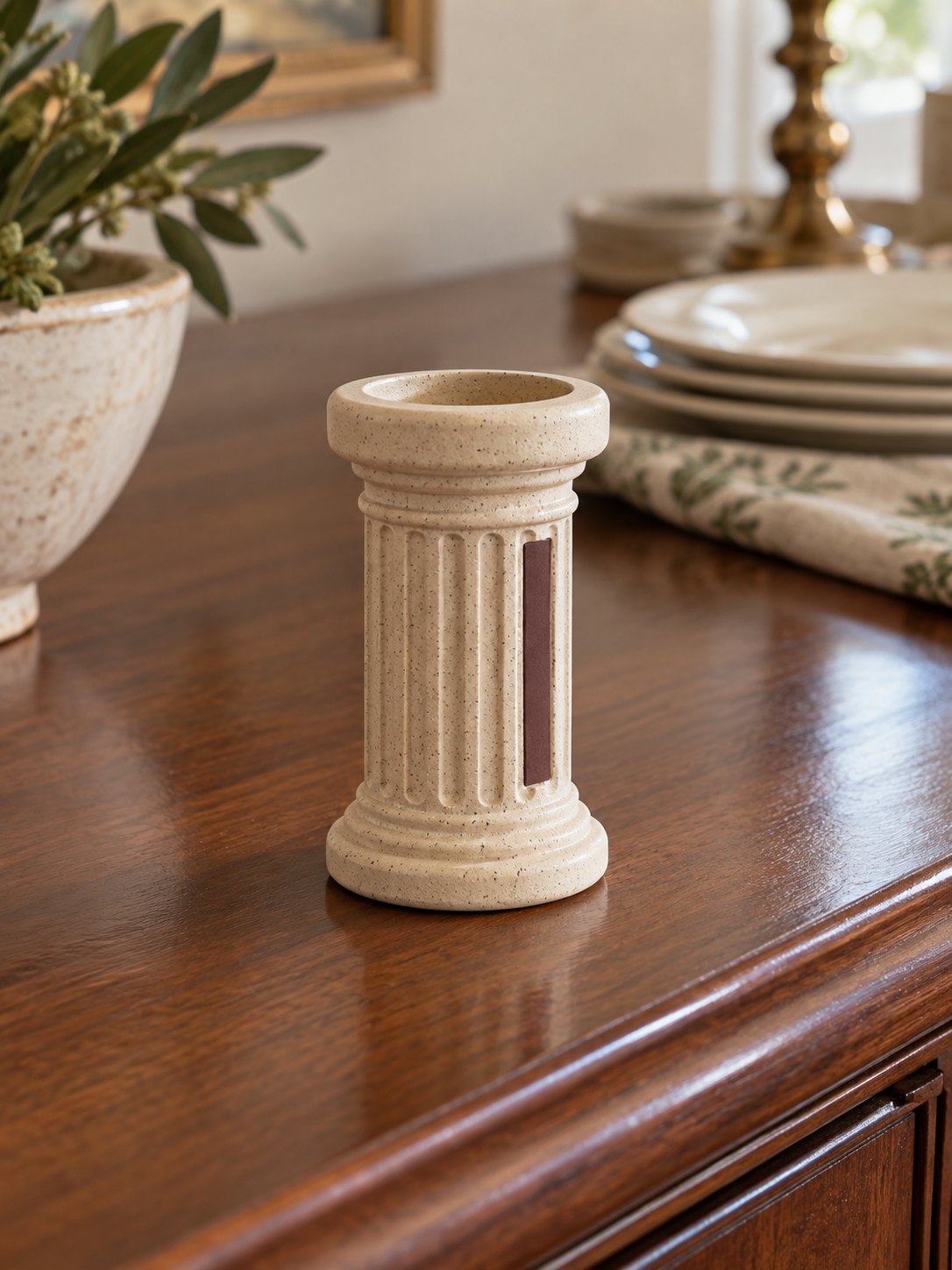 Speckled ceramic column match holder with a side striking pad.